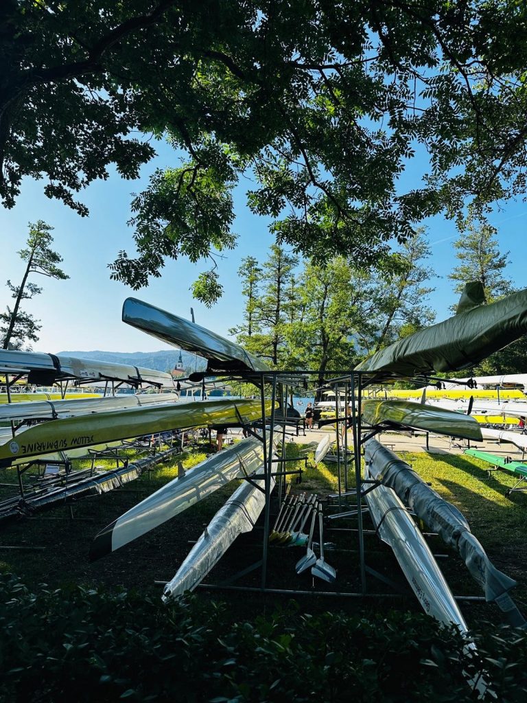 Schmale Ruderboote auf Gestellen am Ufer des Bleder Sees während der Euro Masters Regatta.