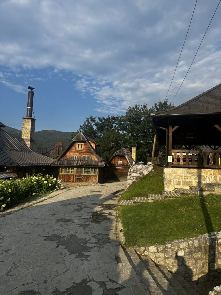 Dorfplatz von Drvengrad mit Holzhäusern in der Abendsonne