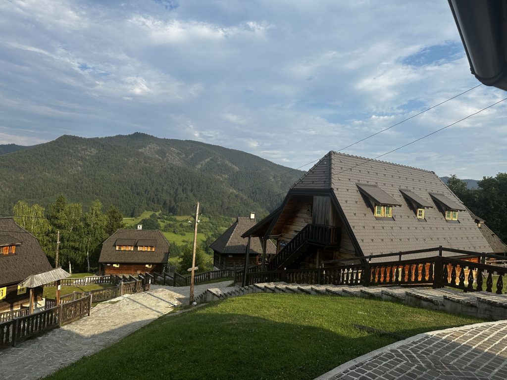 Blick über die Holzdächer von Drvengrad auf die Berge Westserbiens