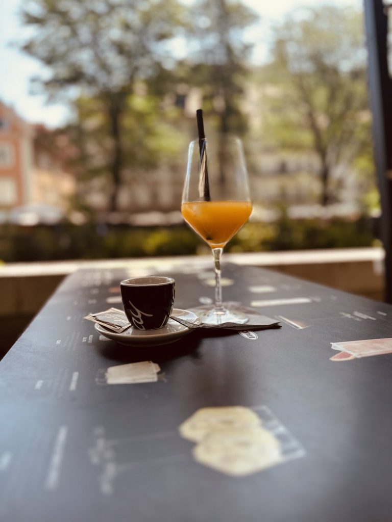 Ein Kaffee und ein Saft auf einem Tisch am Ufer der Ljubljanica in Ljubljana.