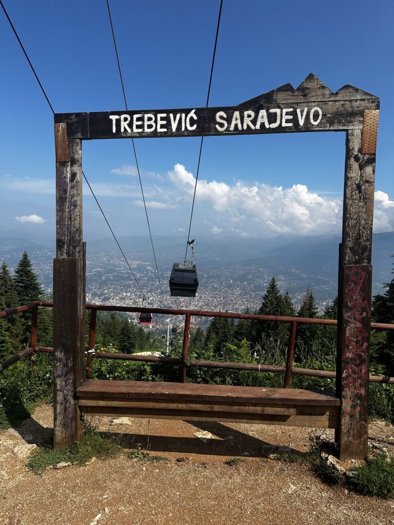 Ein Fotorahmen mit der Aufschrift „Trebević Sarajevo", dahinter eine Seilbahngondel.