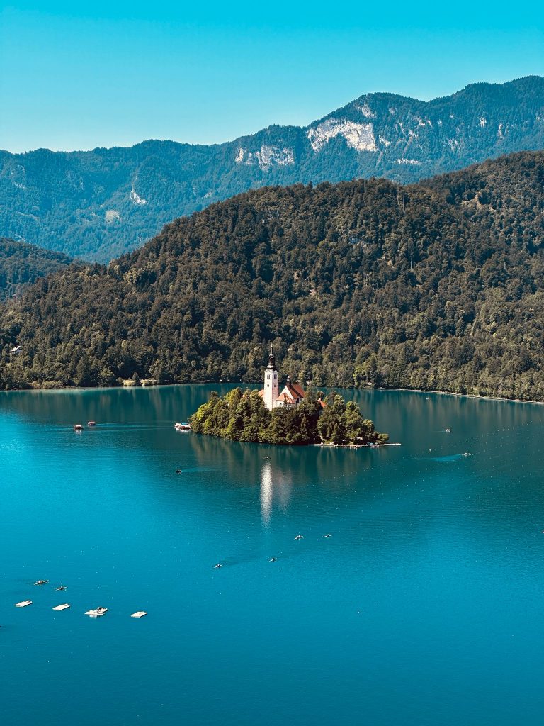 Die Insel mit der Marienkirche im türkisblauen Bleder See vor der Bergkulisse