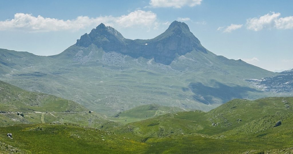 Markanter Doppelgipfel über der grünen Hochebene am Durmitor-Ring in Montenegro