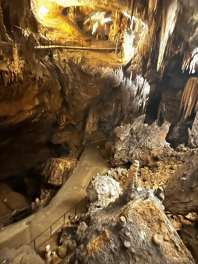 Beleuchteter Höhlengang mit Stalagmiten in der Postojna-Höhle