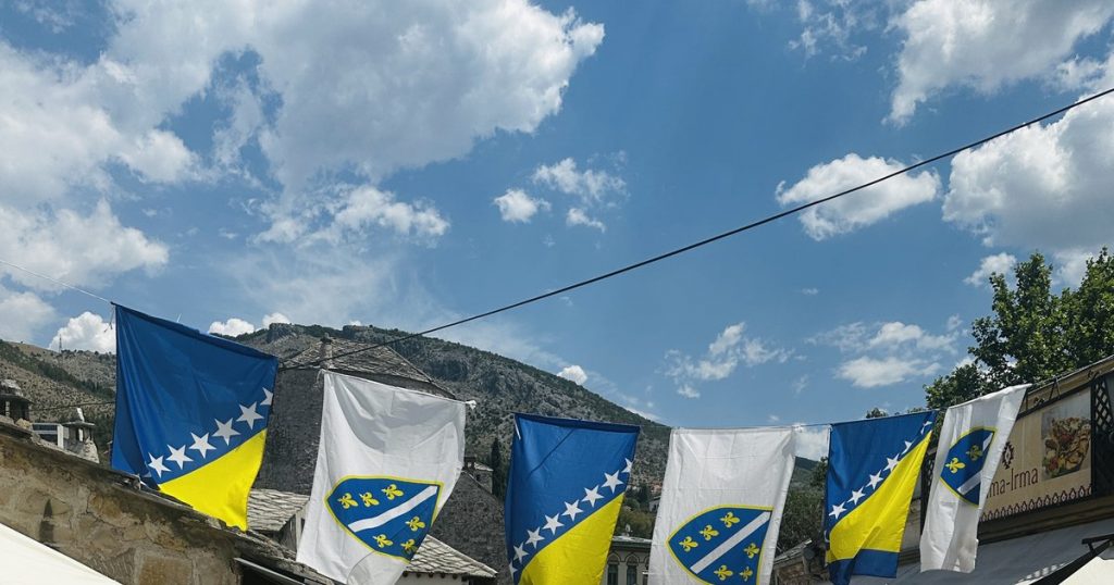Bosnische Staatsflagge und weiße Lilien-Fahne über einer Gasse in Mostars Altstadt