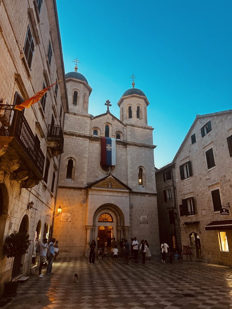 Die beleuchtete orthodoxe Kirche in der Altstadt von Kotor am Abend.